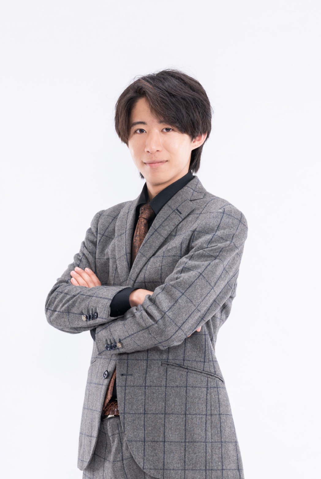 スーツ姿で立つ鈴木健斗のプロフィール写真